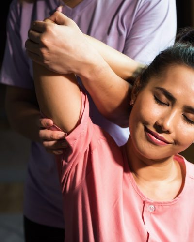 Thai arm and elbow reflexology massage therapy to young beautiful Asian woman on sofa in spa salon. Health care and Relax to heal pain concept. Alternative healthcare industry.